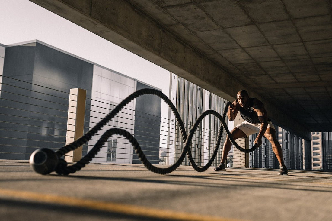 man exercising with battle ropes outdoors