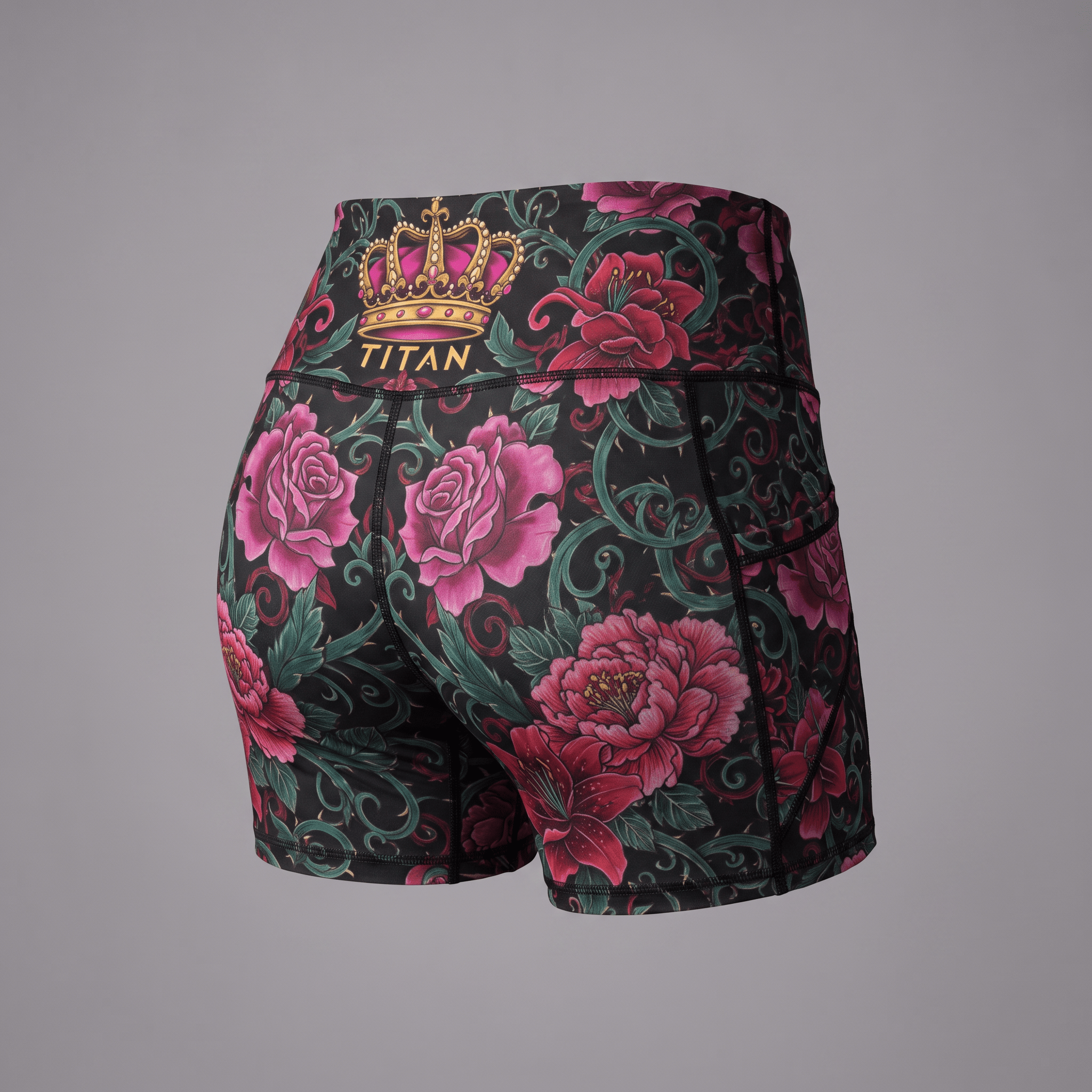 Back view of black athletic shorts with pink roses, green vines, and a gold Titan crown on the waistband.
