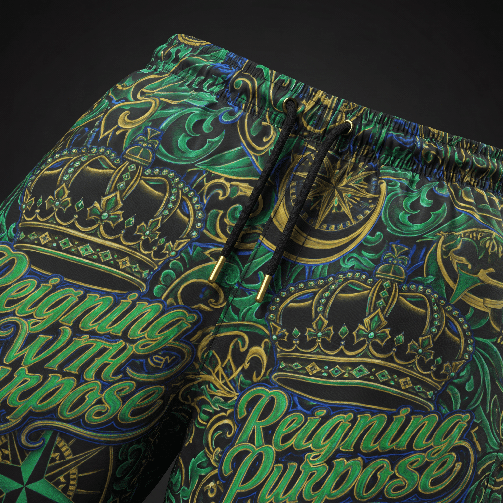 Black shorts featuring a green and gold crown and scrollwork pattern with Reigning with Purpose text and black drawstrings.