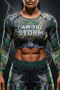 Titan Sport long-sleeve crop top with storm graphic, Aztec-style deity, and "I AM THE STORM" motivational text.