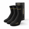 Three black ribbed ankle socks with gold "TITAN" logo at the cuff and toe, presented with branded black packaging.