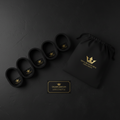 Four black resistance bands, a matching drawstring bag, and a gold-accented box, all with gold crown logos.