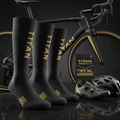 Three-pack of tall black cycling socks with gold TITAN branding and stripes, displayed with a bike, shoe, and helmet.
