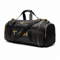 Black TITAN gym duffel bag with gold accents, prominent gold branding, top handles, and a shoulder strap.