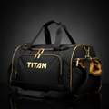 Black TITAN gym duffel bag with gold accents, prominent gold logo, metal hardware, and side pocket on black background.