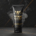 Black tube of Titan Muscle Rub with gold helmet logo, text, and smoky effect on a dark, speckled background.