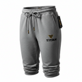 Gray TITAN sweatpants with a drawstring waist, cuffed hems, and a black and gold TITAN logo on the left leg.