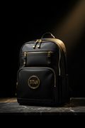 Black TITAN Elite performance backpack with gold zippers and circular gold logo, set on a dark marble surface.